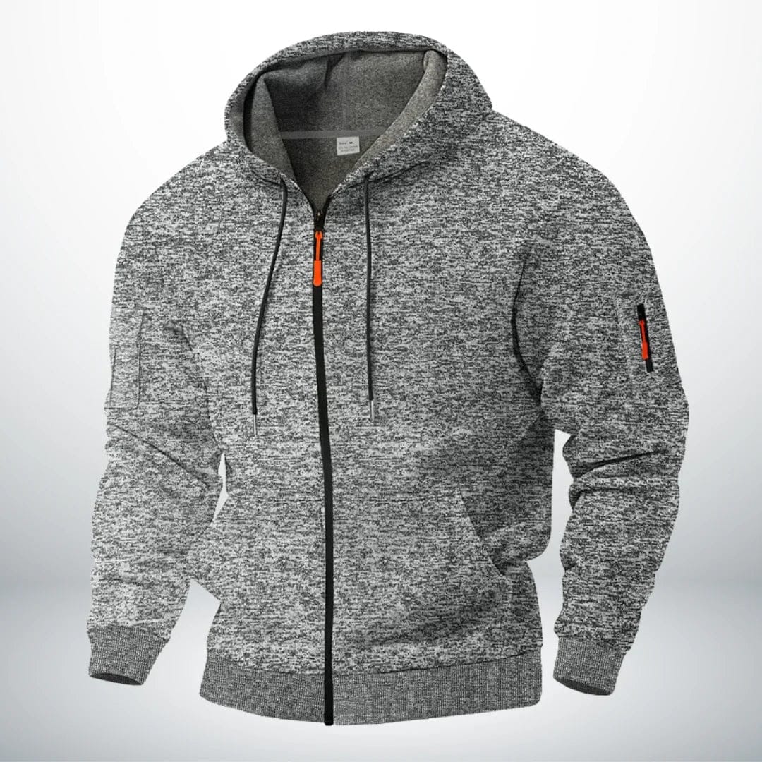 Man draagt de comfortabele Sebastiaan robuuste katoenen hoodie met rits, casual gestyled in een stedelijke omgeving.