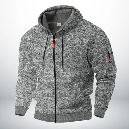 Man draagt de comfortabele Sebastiaan robuuste katoenen hoodie met rits, casual gestyled in een stedelijke omgeving.