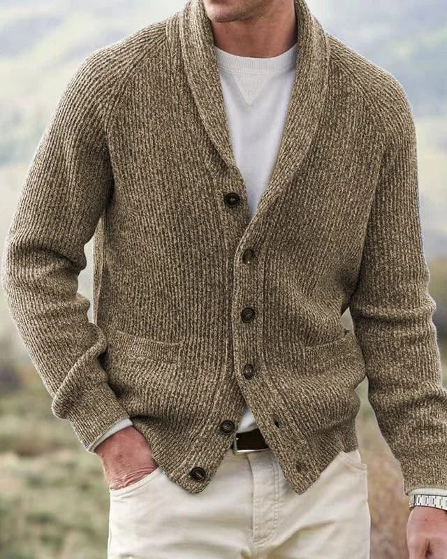 Close-up van de geribbelde stof en de textuur van het groene heren cardigan, die de zachte, wolachtige touch goed weergeeft.