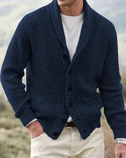 Lifestyle foto van een man in een bruin cardigan, ontspannen zittend, wat de veelzijdigheid en het comfort van dit heren cardigan benadrukt.