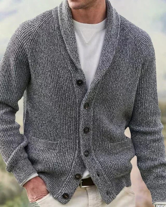 Detailopname van de shawlkraag en de hoorn-effect knopen van het marineblauwe cardigan, met focus op de fijne afwerking.