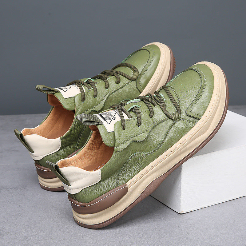 Bruine premium herensneakers gedragen door een man, staand in een stedelijke omgeving, tonend de veelzijdigheid van de sneakers.