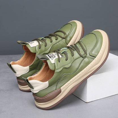 Bruine premium herensneakers gedragen door een man, staand in een stedelijke omgeving, tonend de veelzijdigheid van de sneakers.