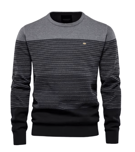 Detailopname van de fijne breistructuur en geribbelde boorden van de elegante katoenen heren sweater in grijs.