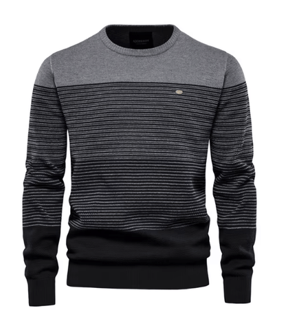 Detailopname van de fijne breistructuur en geribbelde boorden van de elegante katoenen heren sweater in grijs.
