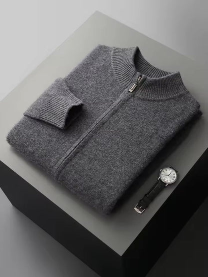 Vier opgevouwen Merino wollen sweaters in diverse kleuren, netjes gestapeld op een plank.