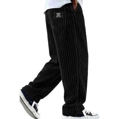 Man draagt de comfortabele zwarte trousers tijdens een casual wandeling, toont de moeiteloze pasvorm.