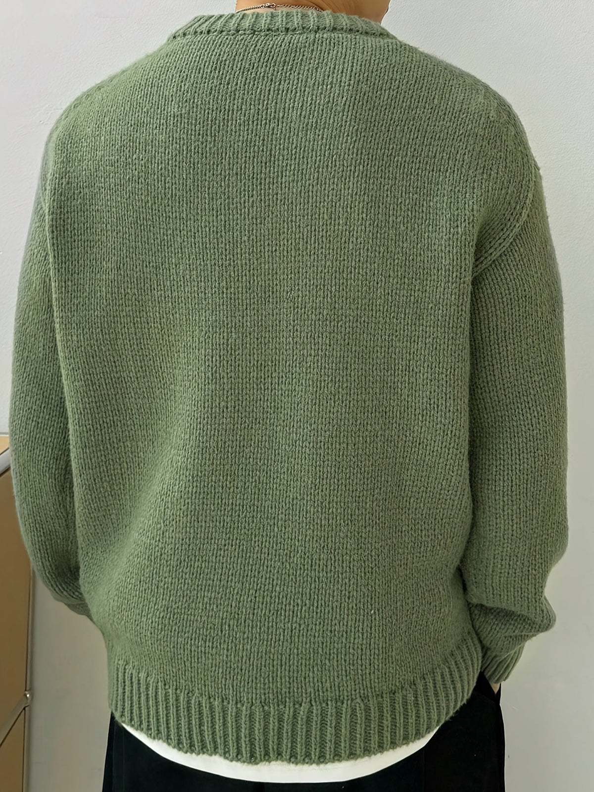 Detail van de mouwboorden en de onderkant van de marineblauwe heren sweater, met aandacht voor de afwerking.