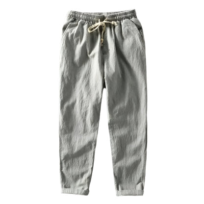 Close-up van de textuur en de tailleband van de grijze linnen trousers, gedetailleerd en elegant.