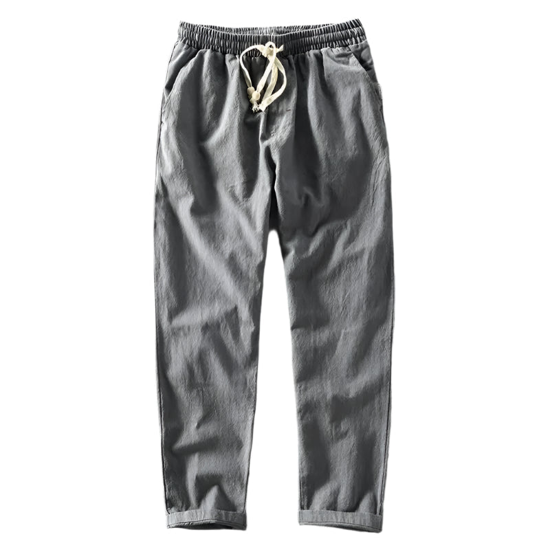 Een model toont de marineblauwe linnen trousers in een dynamische loopbeweging, benadrukt de soepele stof.