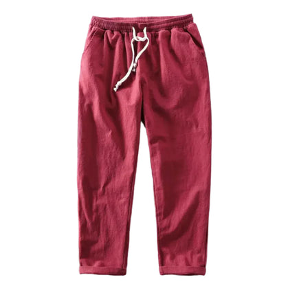 Detailopname van de zakken en stiksels van de rode linnen trousers, kwaliteit en afwerking zichtbaar.