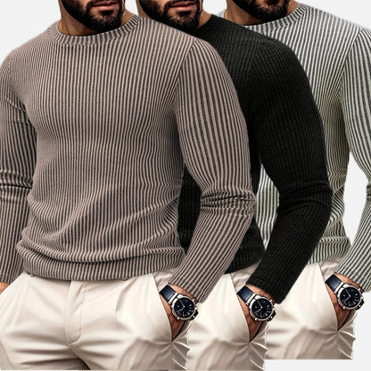 Stapel van de diverse kleuren geribbelde heren sweaters, wit, zwart, beige, groen en bruin, klaar voor verzending.