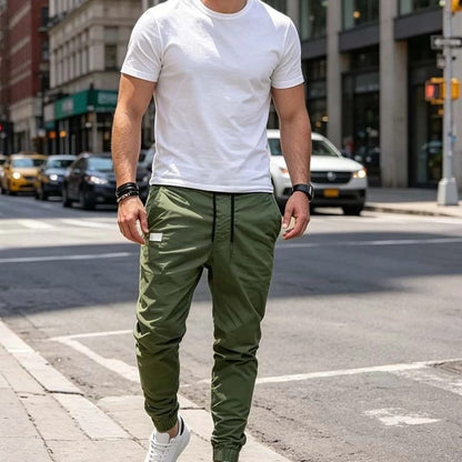 Man combineert de grijze cargobroek met een casual overhemd, toont de veelzijdigheid voor diverse outfits.