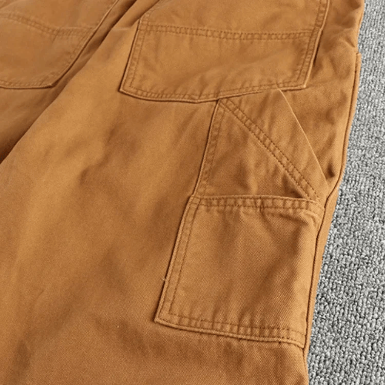 Een man combineert de blauwe utility broek met een casual overhemd, wat de veelzijdigheid van de broek benadrukt.