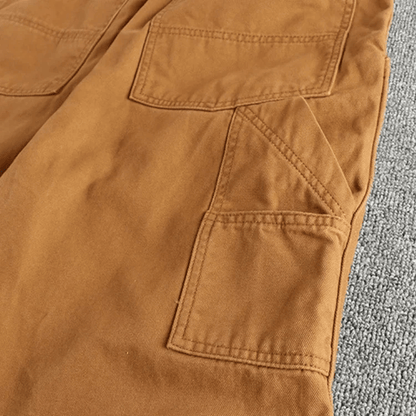 Een man combineert de blauwe utility broek met een casual overhemd, wat de veelzijdigheid van de broek benadrukt.