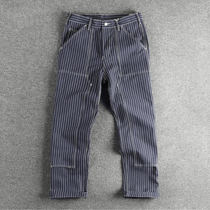 Detailopname van de versterkte dubbele kniepanelen op de kaki utility broek, met focus op de textuur van het katoen.