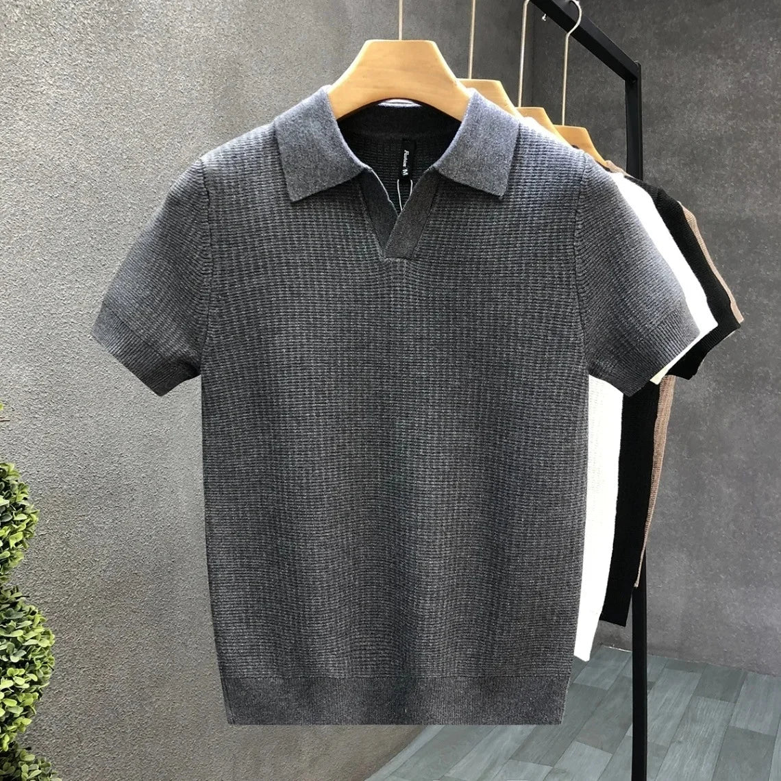 Close-up van de knoopsluiting en kraag van het Jasper ademende gebreide poloshirt in het zwart.
