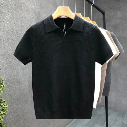 Een detail van de mouw en de zoom van het Jasper ademende gebreide poloshirt, wat de kwaliteit toont.