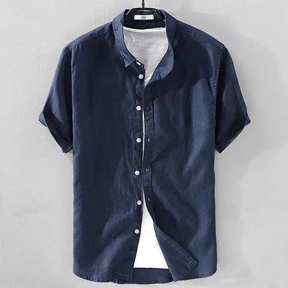 Zijaanzicht van een man die het Julius overhemd met korte mouwen draagt, casual gestyled met een broek, in een ontspannen houding.