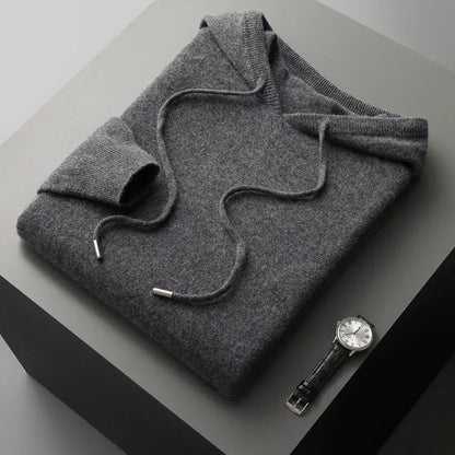 Man poseert casual in een grijze merinowollen hoodie, toont comfort en bewegingsvrijheid.