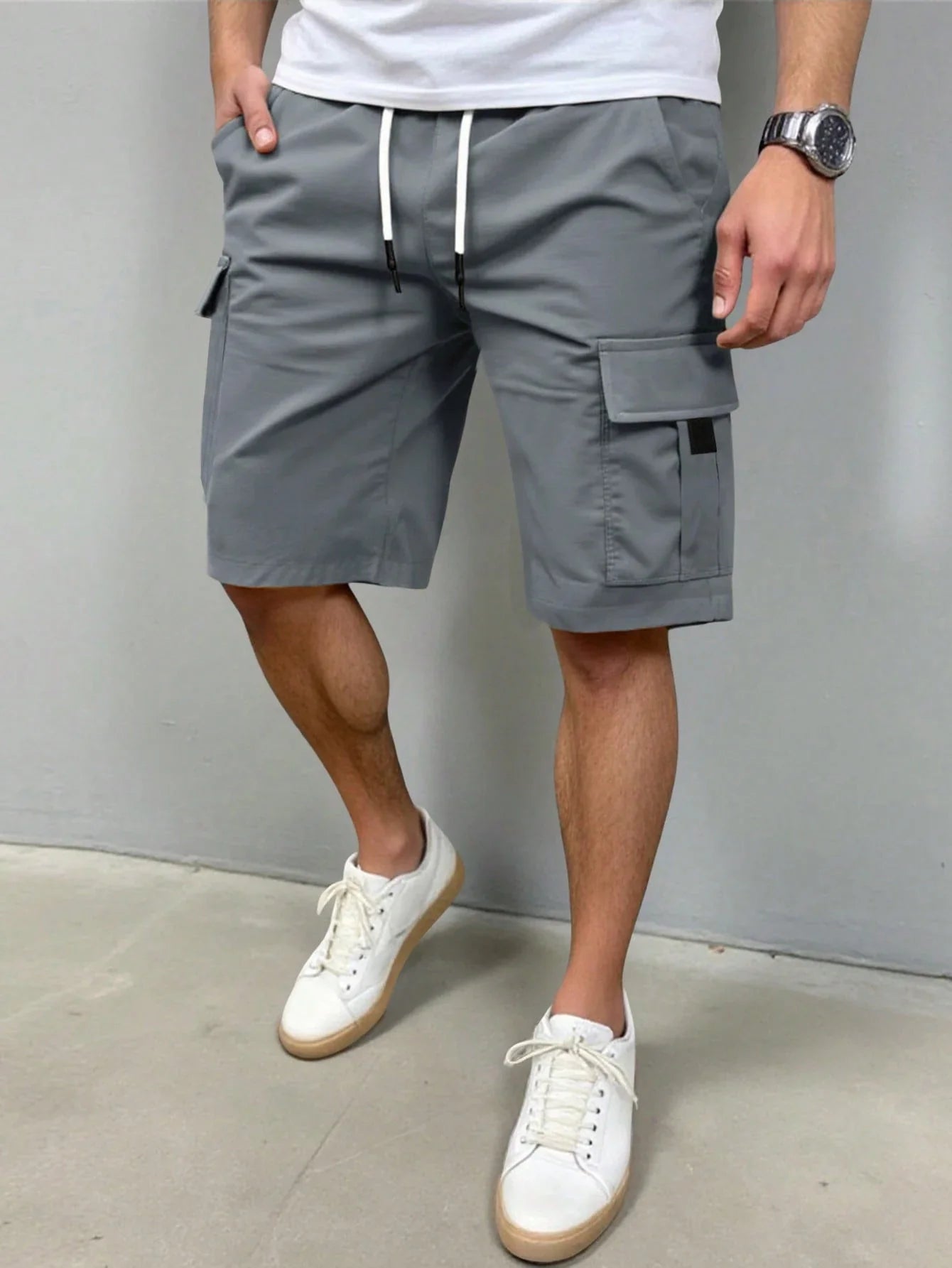 Vooraanzicht van de Lennart cargoshorts in tijdloos grijs, liggend op een lichte ondergrond.