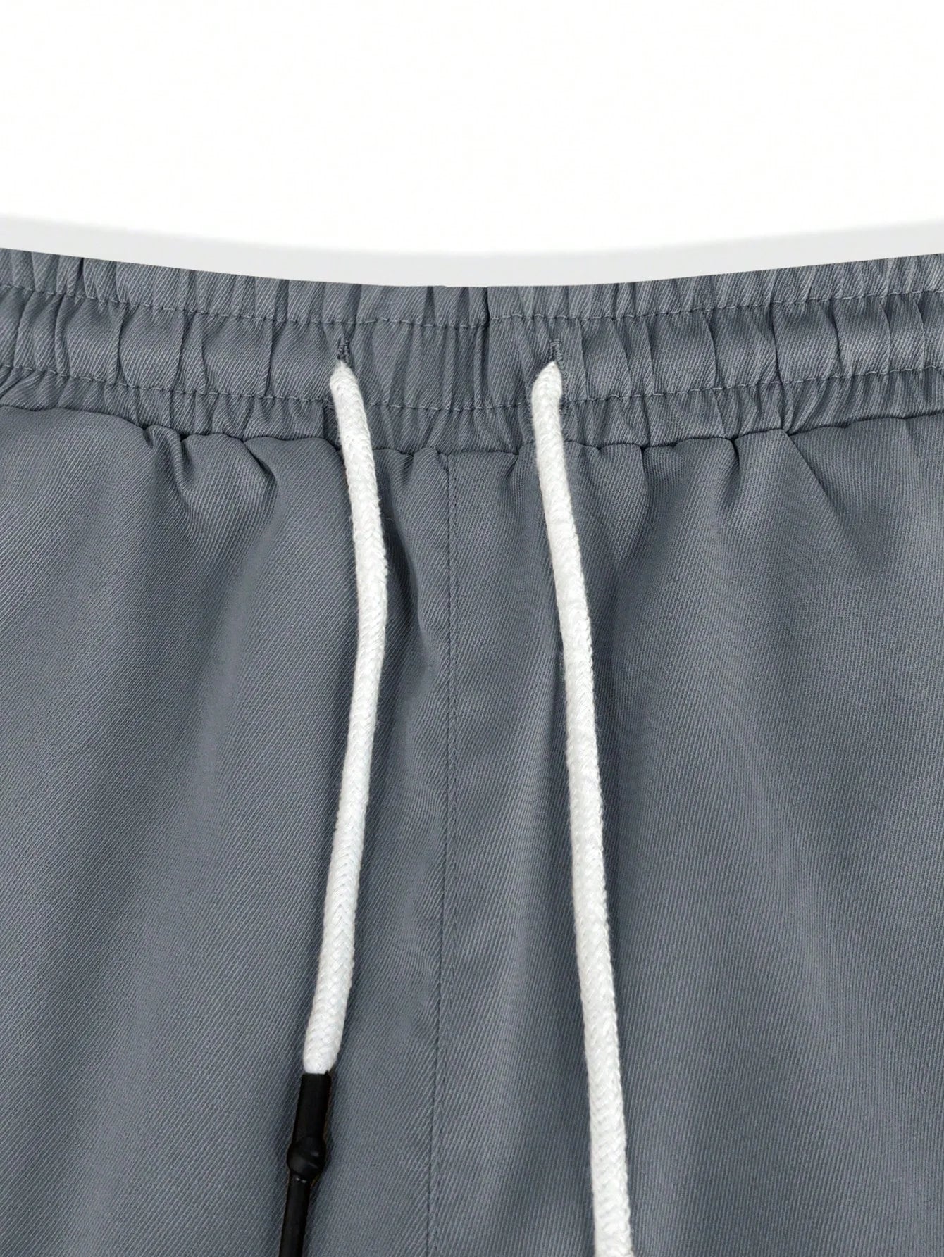 Zijaanzicht van de witte Lennart cargoshorts, waarbij de ruime zakken op de dijen opvallen.