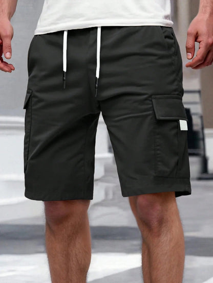 Detailopname van de tailleband van de beige cargoshorts, inclusief riemlussen en knoopsluiting.