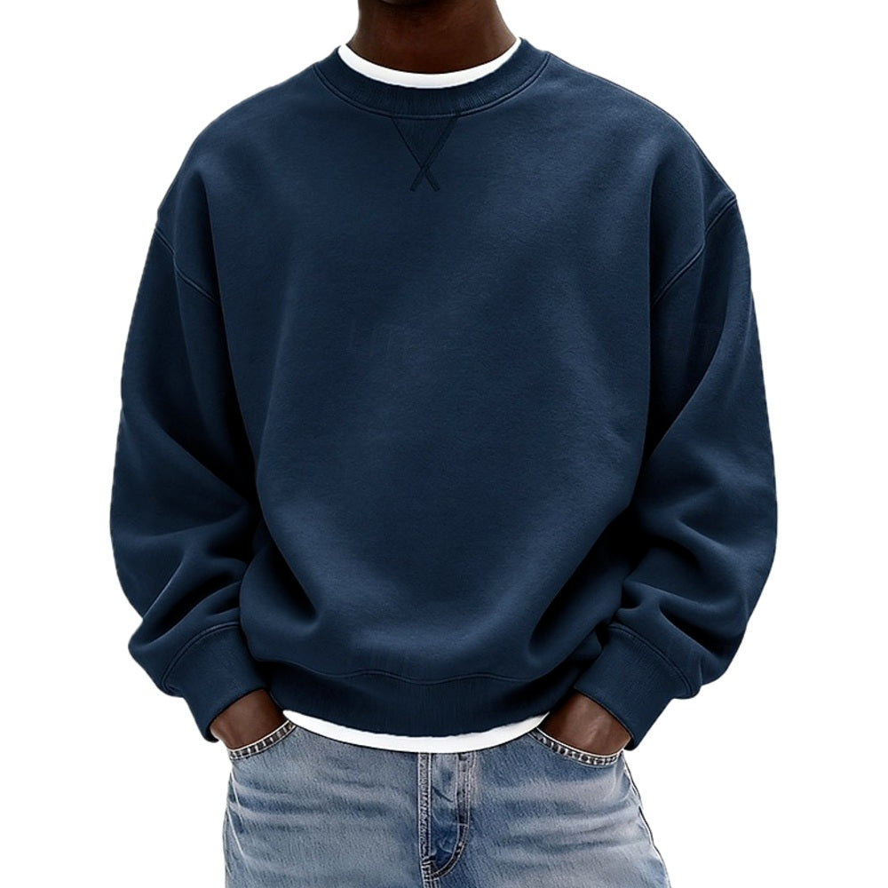 Man draagt de grijze katoenen sweater in een ontspannen houding, gecombineerd met een jeans voor een casual look.