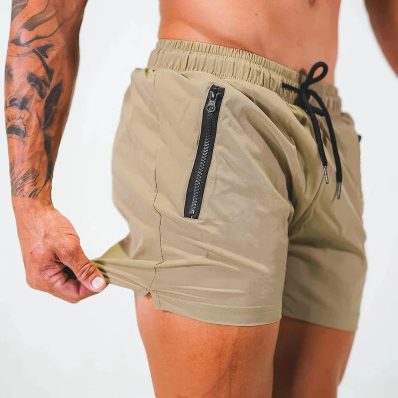 Een stapel verschillende kleuren Max zwemshorts (rood, khaki, zwart, marineblauw, groen) netjes opgevouwen, klaar voor gebruik.