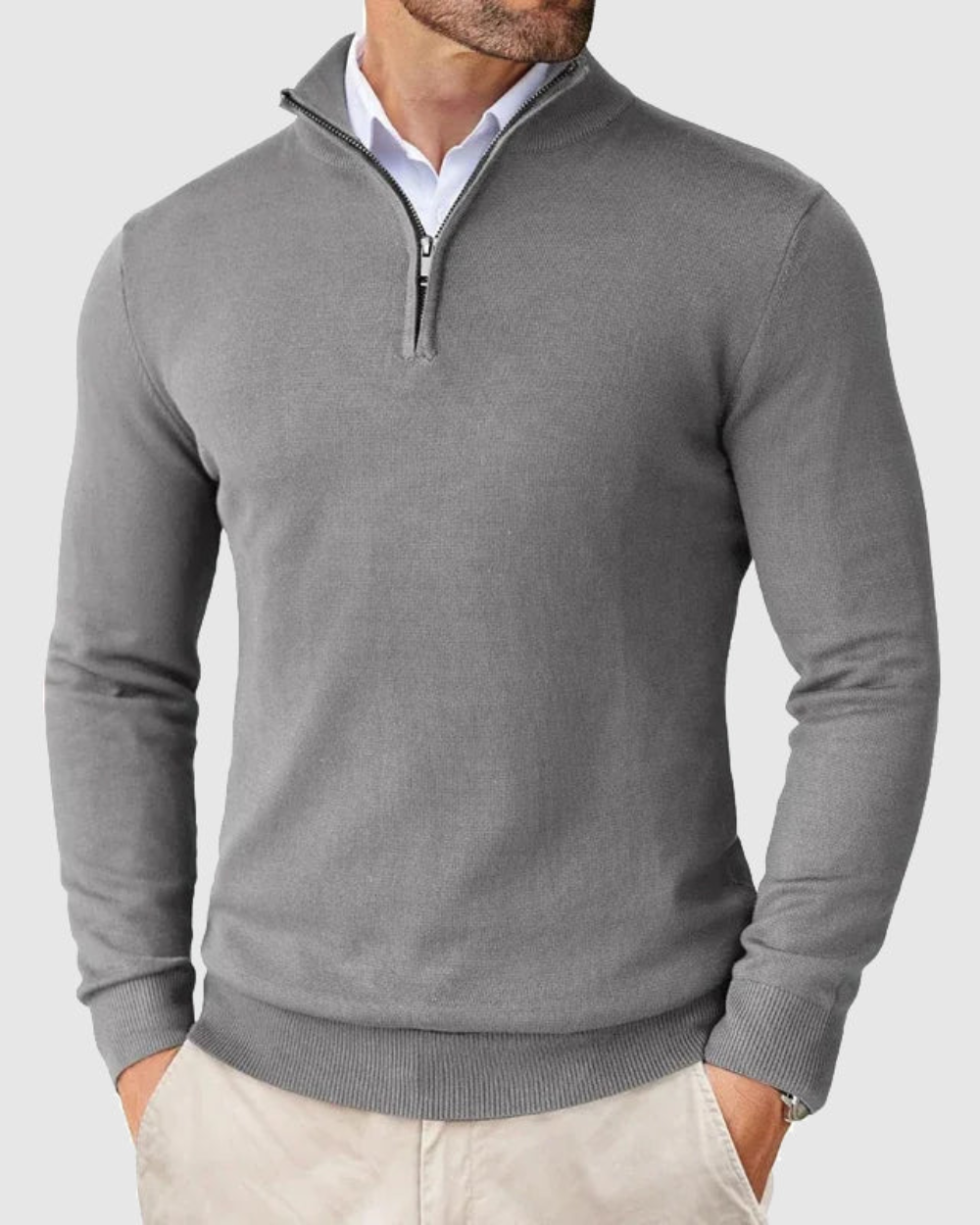 Detailopname van de strakke ritssluiting en de hoogwaardige stof van de grijze sweater.