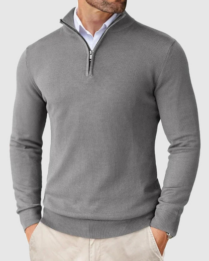Detailopname van de strakke ritssluiting en de hoogwaardige stof van de grijze sweater.