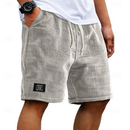 Zijaanzicht van de grijze wafelkatoenen shorts, met nadruk op de textuur van de stof en de pasvorm.