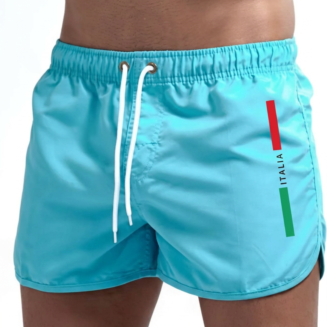 Detaillering van de elastische tailleband met trekkoord van de rode Otis zwemshort, voor een aanpasbare pasvorm.