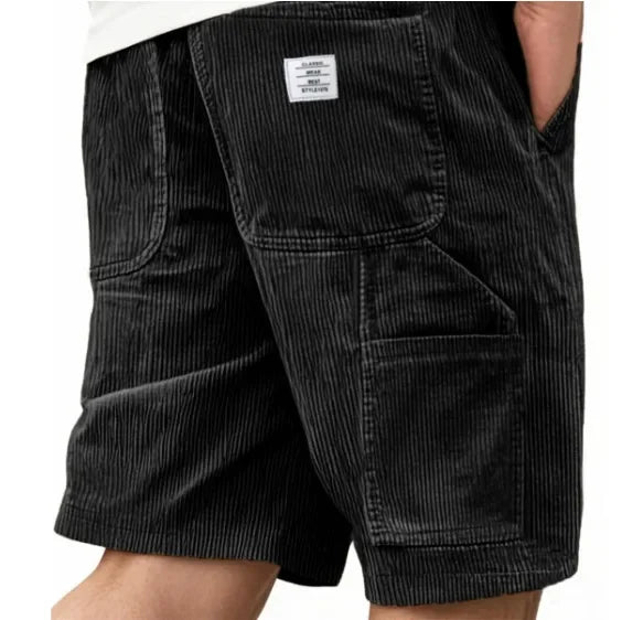 Man die de Remi comfortabele cargoshort in roze draagt, zittend in een ontspannen houding, toont bewegingsvrijheid.