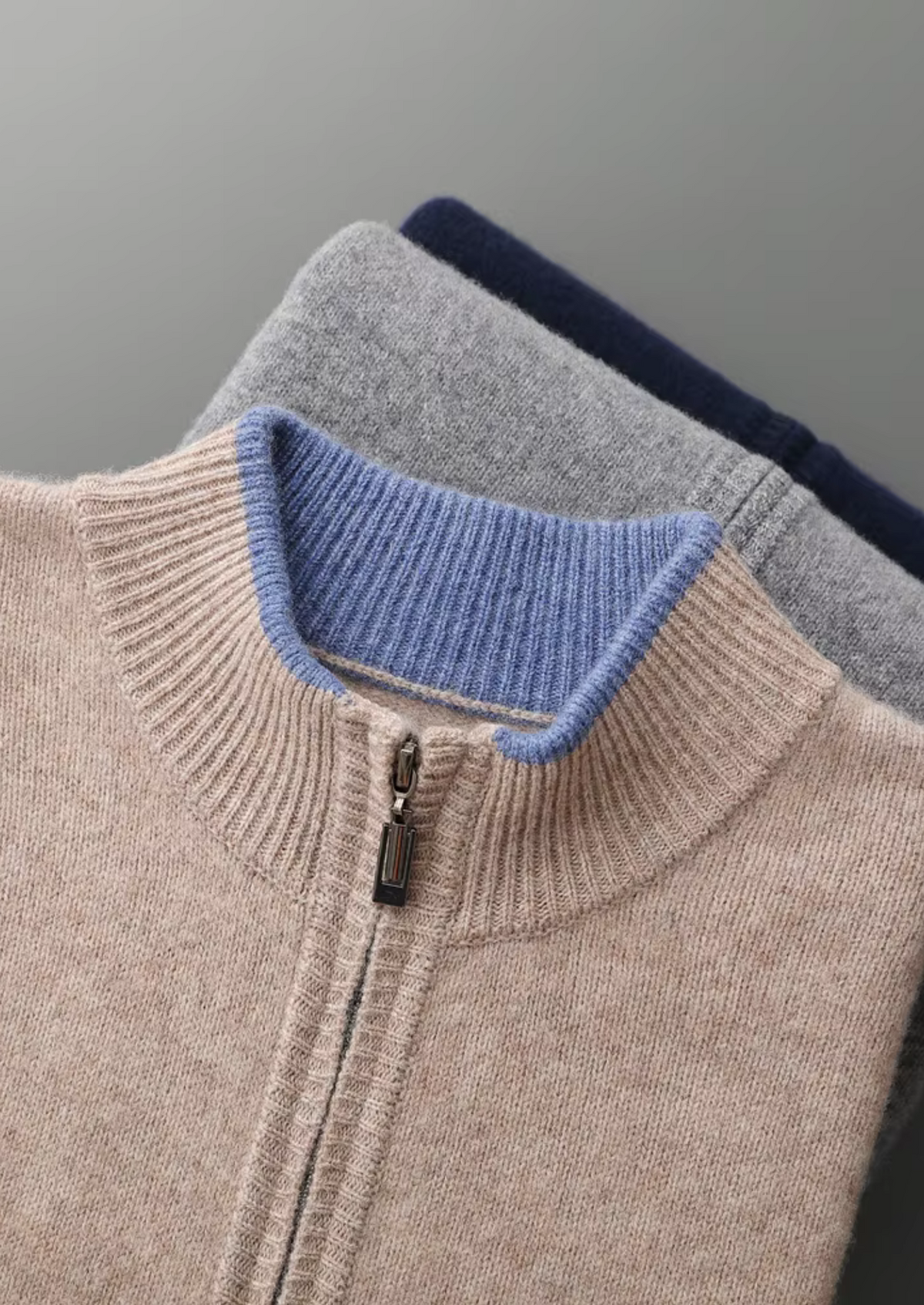 Stapel van drie cardigans in verschillende kleuren (grijs, beige, donkerblauw), toont kleuropties.