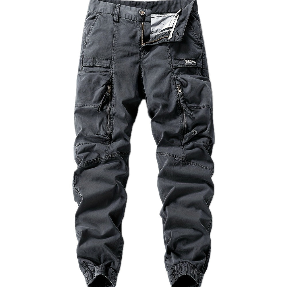 Zijaanzicht van de grijze cargo jogger broek gedragen door een man, gecombineerd met sneakers voor een casual look.