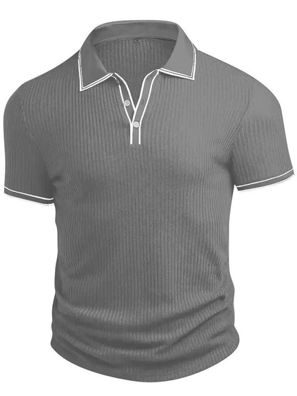Een man die het witte geribbelde gebreide poloshirt combineert met een nette broek, ideaal voor een zakelijke casual setting.
