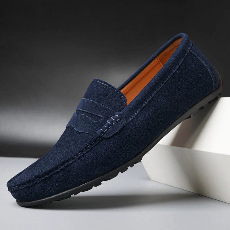 Een man draagt marineblauwe Fabian loafers in een casual setting, gecombineerd met een chino, voor een realistische weergave.