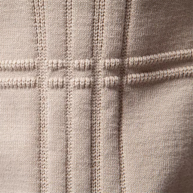 Beige heren trui liggend op een plat oppervlak, met aandacht voor de gelijkmatige stiksels en kleur.